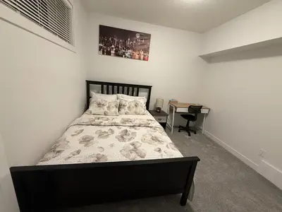 a bedroom with a bed and a desk in it at Peace Haven in Edmonton