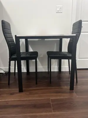 a black dining room table and two chairs at Kizito in Edmonton