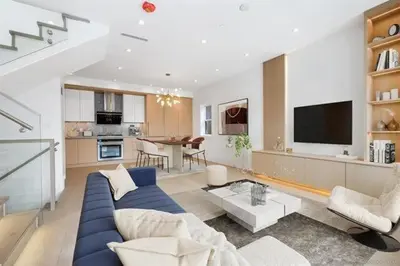a living room with a blue couch and a kitchen at Luxury & brand-new Cozy duplex in South Vancouver in Vancouver