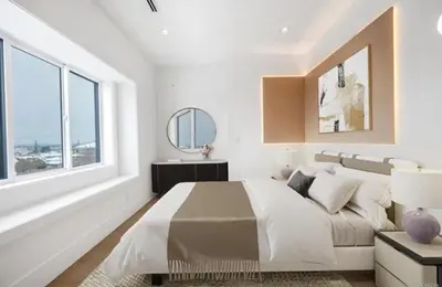 a white bedroom with a large bed and a window at Luxury & brand-new Cozy duplex in South Vancouver in Vancouver