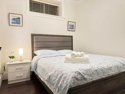 a bedroom with a bed with two towels on it at Cozy 3 BR Suite Ideal for Families and Groups in Vancouver