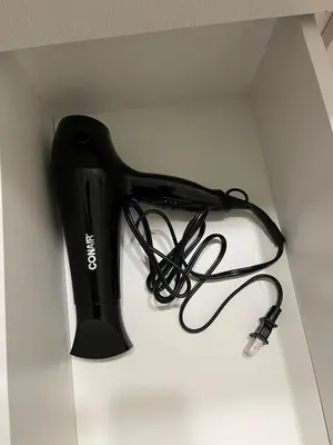 a black hair dryer sitting on top of a table at cozy basement suite with 1-bed, wi-fi & Neflix in Edmonton