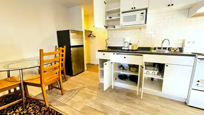 a small kitchen with a table and a microwave at Cloud 9 Inn in Whitecourt