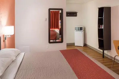 a bedroom with a bed and a mirror in it at Motel 6-Fort St. John, BC in Fort Saint John