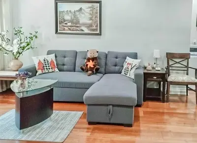a living room with a blue couch and a teddy bear at Luxury 1200 squft 2BR Shaughnessy Suite Near YVR & DT in Vancouver