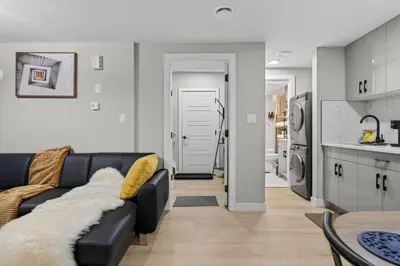 a living room with a black couch and a kitchen at Guest Suite in Edmonton, King bed and parking in Edmonton