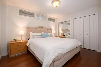 a bedroom with a large white bed and a mirror at Comfort Spacious 2-BR Suite in Arbutus in Vancouver