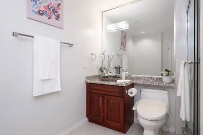 a bathroom with a toilet and a sink and a mirror at Comfort Spacious 2-BR Suite in Arbutus in Vancouver