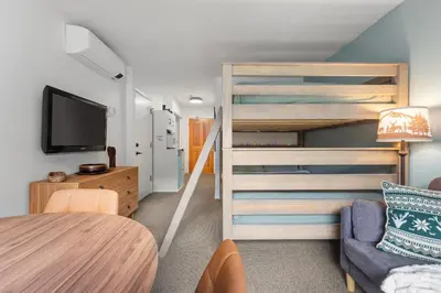 a small room with a bunk bed and a couch at 1BR | Greystone Lodge | Ski in / Ski out | Pool & Hot Tub | Epic Locations in Whistler