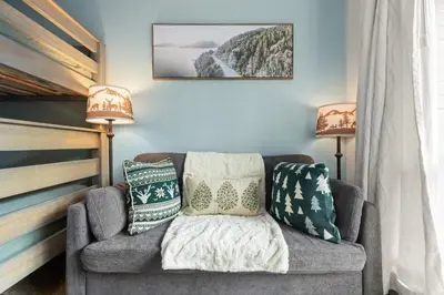 a living room with a couch and two lamps at 1BR | Greystone Lodge | Ski in / Ski out | Pool & Hot Tub | Epic Locations in Whistler