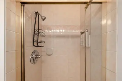 a shower with a glass door with a shower head at 1BR + Sofa Bed | Greystone Lodge | Ski in / Ski out | Pool & Hot Tub | Epic Locations in Whistler