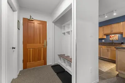 a hallway with a door leading to a kitchen at 2BR + Sofa Bed | Greystone Lodge | Ski in / Ski out | Split home living | Pool & Hot Tub in Whistler