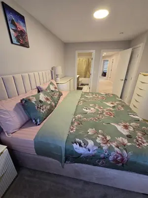 a bedroom with a bed with a floral bedspread at Cozy Comfort Homestaed-Near Airport in Calgary