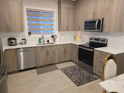 a kitchen with a sink and a stove top oven at Cozy Comfort Homestaed-Near Airport in Calgary