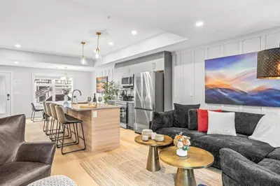 a living room with a couch and a kitchen at Skyridge Mountain Retreat 4BR with BBQ Near Banff in Canmore