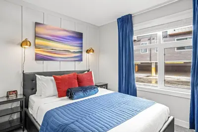 a bedroom with a bed with blue curtains and a window at Skyridge Mountain Retreat 4BR with BBQ Near Banff in Canmore