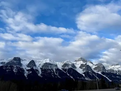 a snow covered mountain range with a cloudy sky at Mountain Retreat with Views and Hot Tub Near Banff Gates in Canmore