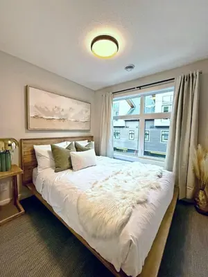 a bedroom with a large bed with a large window at Mountain Retreat with Views and Hot Tub Near Banff Gates in Canmore