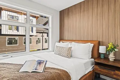 a bedroom with a bed with a book on it at Cozy 3BR Mountainside Haven Near Banff in Canmore