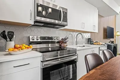a kitchen with a stove and a bowl of fruit at Cozy 3BR Mountainside Haven Near Banff in Canmore