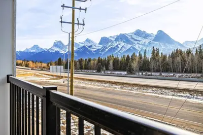 a view from a balcony of a road with mountains at 3BR Rockies Haven Near Banff with Private Patio in Canmore