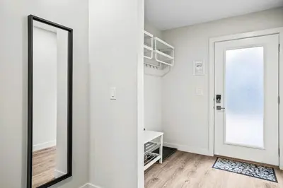 a mirror in a white room with a door at 3BR Rockies Haven Near Banff with Private Patio in Canmore