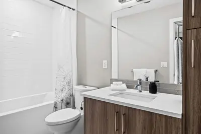 a white bathroom with a sink and a toilet at 3BR Rockies Haven Near Banff with Private Patio in Canmore