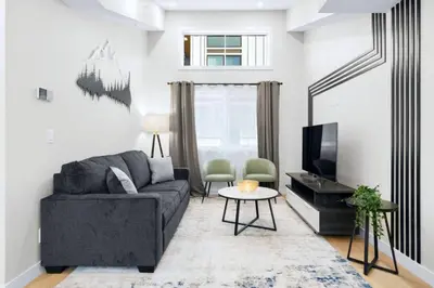 a living room with a couch and a tv at Scenic 3BR Townhouse with Mountain Views Near Banff in Canmore