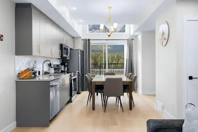 a kitchen with a table and a dining room at Scenic 3BR Townhouse with Mountain Views Near Banff in Canmore