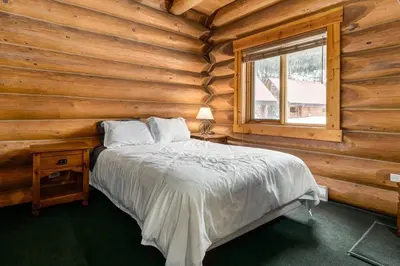 a bedroom with a bed in a log cabin at Beautiful Cottage In The Heart Of The Rockies in Golden