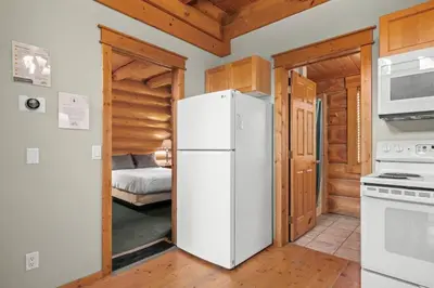 a kitchen with a white refrigerator and a bedroom at Rustic Chalet Perfect Getaway for Groups in Golden