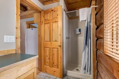 a kitchen with a shower and a wooden door at Wonderful Rockies Cabin Getaway for Hike or Ski in Golden