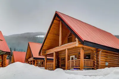 a log cabin with a red roof in the snow at Wonderful Rockies Cabin Getaway for Hike or Ski in Golden