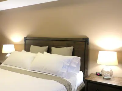 a bedroom with a bed with white sheets and two lamps at Luxury Canmore Vacations in Canmore