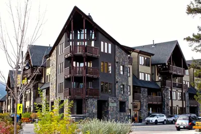 a large building with wooden balconies on a street at Luxury Canmore Vacations in Canmore