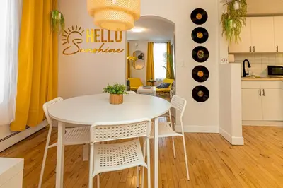 a kitchen and dining room with a white table and chairs at Quiet Yellow Unit- Stampede, BMO, Nightlife Etc. in Calgary