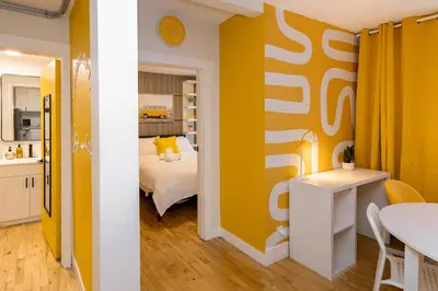 a room with a bed and a table and a kitchen at Quiet Yellow Unit- Stampede, BMO, Nightlife Etc. in Calgary