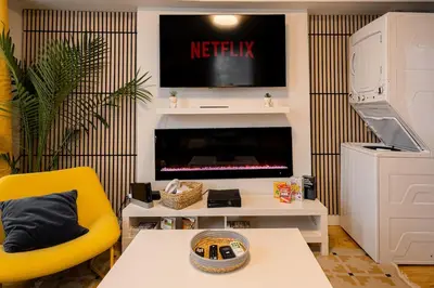 a living room with a tv and a yellow chair at Quiet Yellow Unit- Stampede, BMO, Nightlife Etc. in Calgary