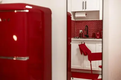 a red kitchen with a red chair in a room at Retro-Chic Hideaway - Walking Distance To Stampede in Calgary