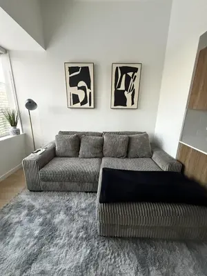 a living room with a couch and two pictures on the wall at Luxury Downtown One Bedroom with Skyline Views and Free Parking in Edmonton