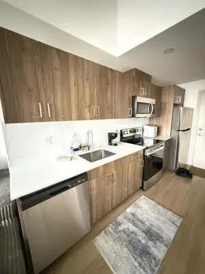 a kitchen with wooden cabinets and stainless steel appliances at Luxury Downtown One Bedroom with Skyline Views and Free Parking in Edmonton