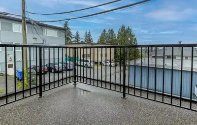 a balcony with a fence with cars in a parking lot at Large 3 Bedroom Laneway House in Vancouver