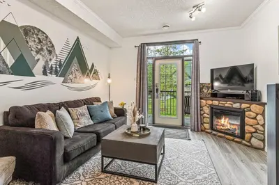a living room with a couch and a fireplace at Stylish Mountain Retreat 2BR Chalet and Hot Pool in Canmore