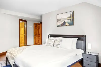 a bedroom with a large bed with white sheets at 2BR MTN Canmore Retreat with Private Balcony in Canmore