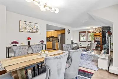 a dining room and living room with a table and chairs at 2BR MTN Canmore Retreat with Private Balcony in Canmore