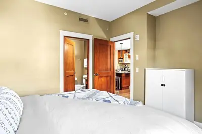 a bedroom with a white bed and a refrigerator at Serene 2BR Solara Escape with BBQ Pool and Hot Tub in Canmore