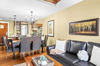a living room with a couch and a table at Serene 2BR Solara Escape with BBQ Pool and Hot Tub in Canmore