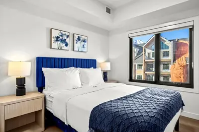 a bedroom with a bed and a large window at 3BR Rockies Have Sleeps 8 with Hot Tub Pool and Mtn Views in Canmore