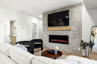 a living room with a couch and a fireplace at 3BR Rockies Have Sleeps 8 with Hot Tub Pool and Mtn Views in Canmore
