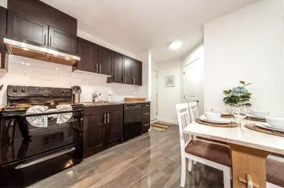 a kitchen with a stove and a table with chairs at 3BDRM Winter Haven - King Beds - Fireplace - Garage in Edmonton